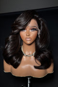 Mannequin head with a dark brown wig on a black background